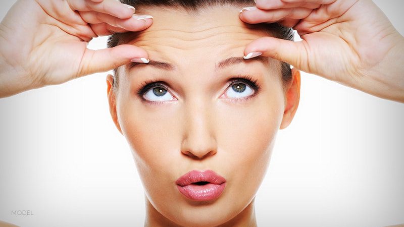 Female squeezing area above eyebrows together with hands