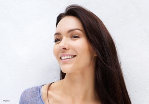Headshot of woman with dark brown hair a sculpted nose looking to the side